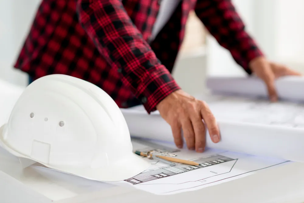 Hard hat beside rolled plans